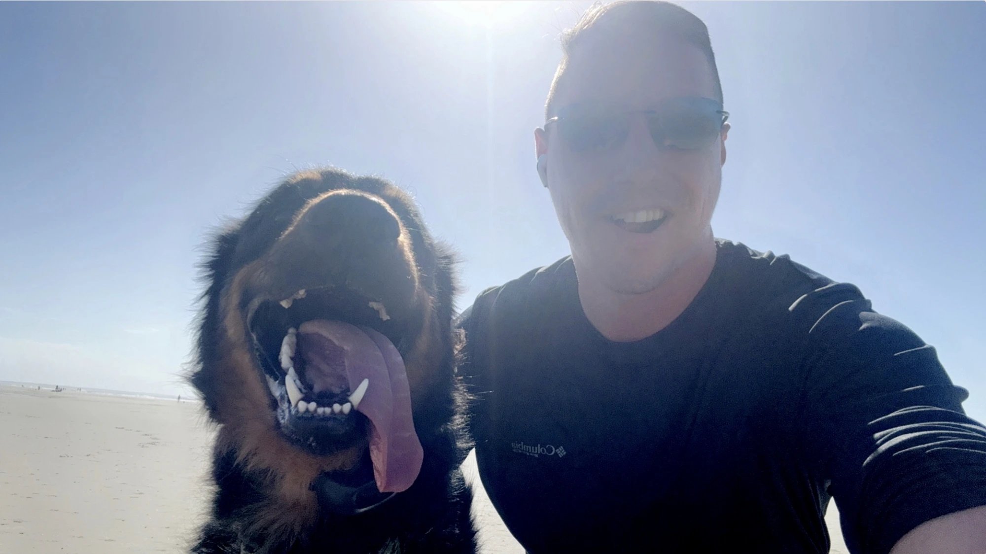 Chad, owner of Tides Team Exteriors, with his dog on the beach